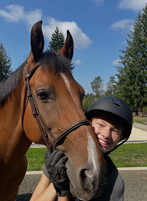 Madison hugging her bay horse on a sunny Pacific Northwest morning